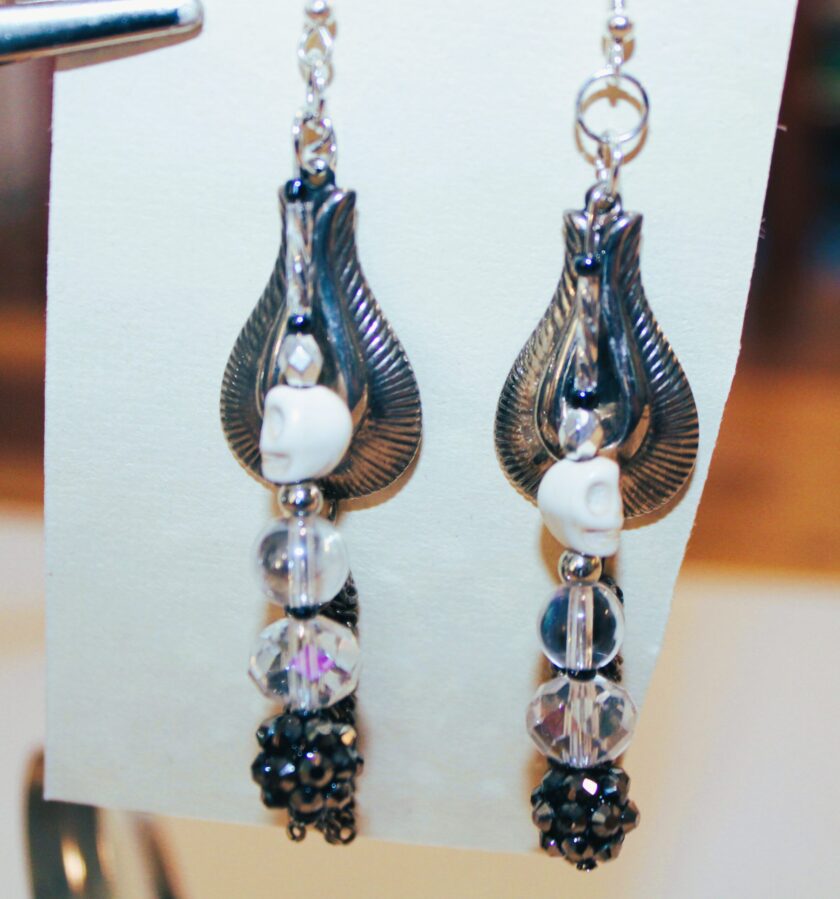 A pair of earrings with a skull on them.