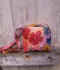 Colorful painted flowers adorn an upcycled bag with beaded accents
