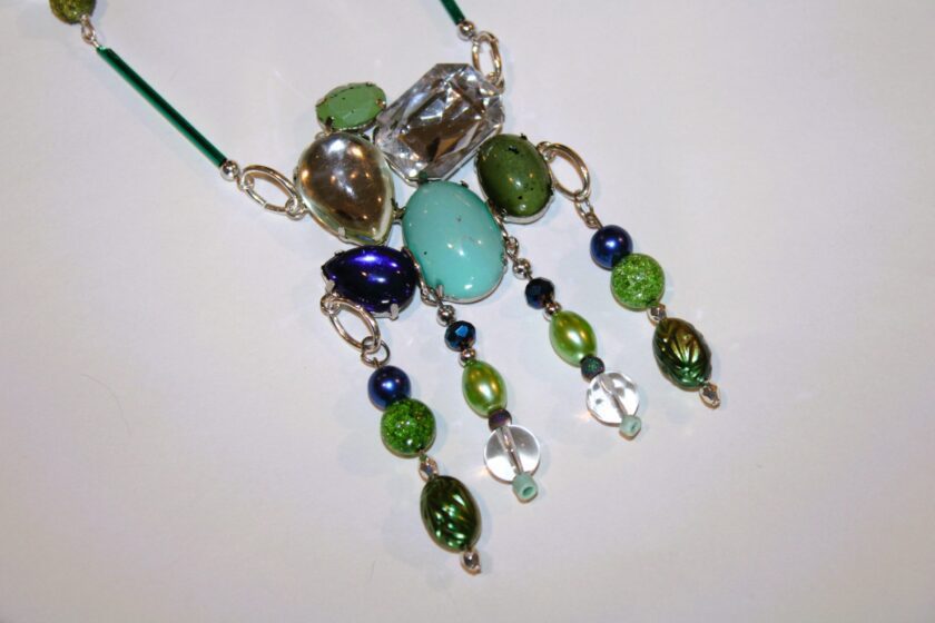 A necklace with green and blue beads on it.