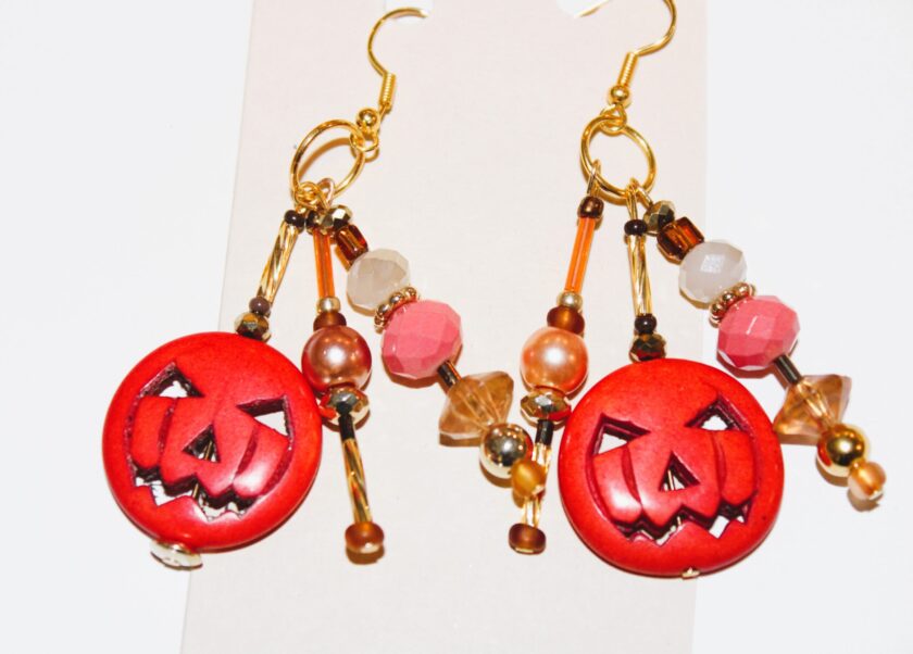 A pair of pierced earrings with jack o lanterns on them.