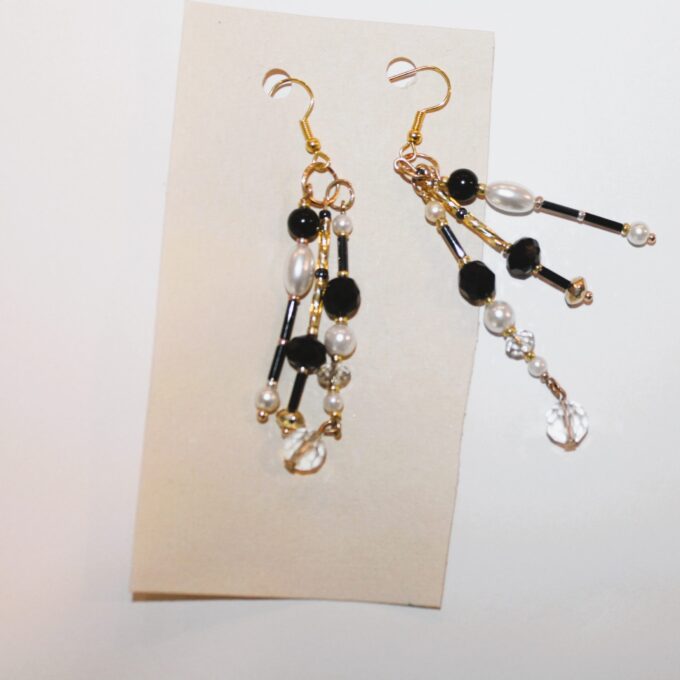 A pair of black and white earrings on a piece of paper.