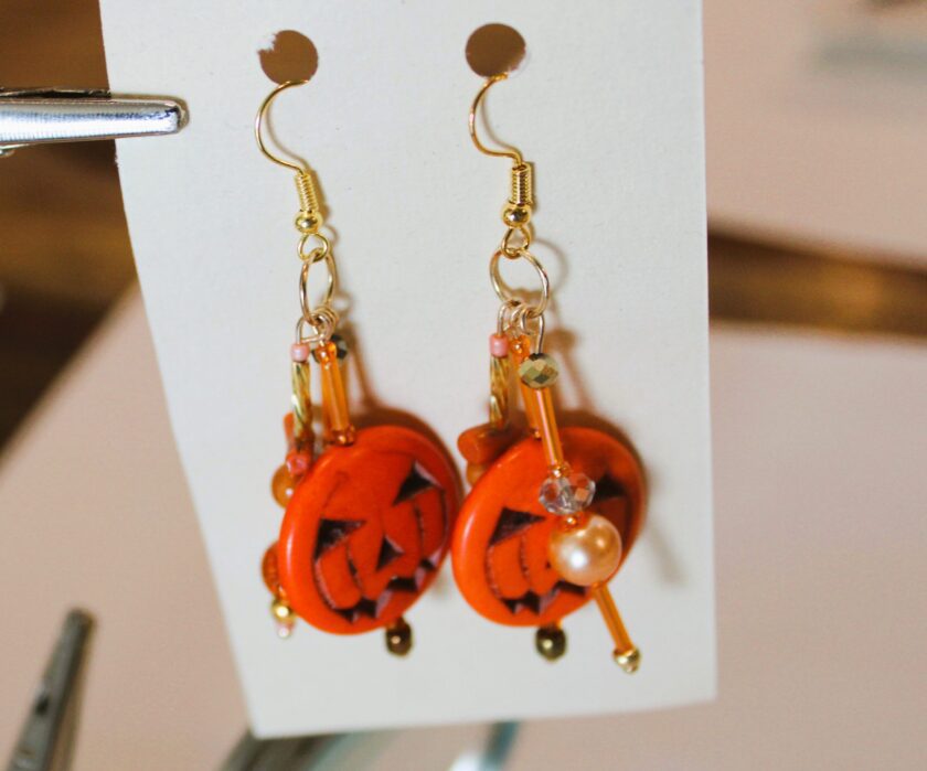 A pair of earrings with a jack o lantern on them.