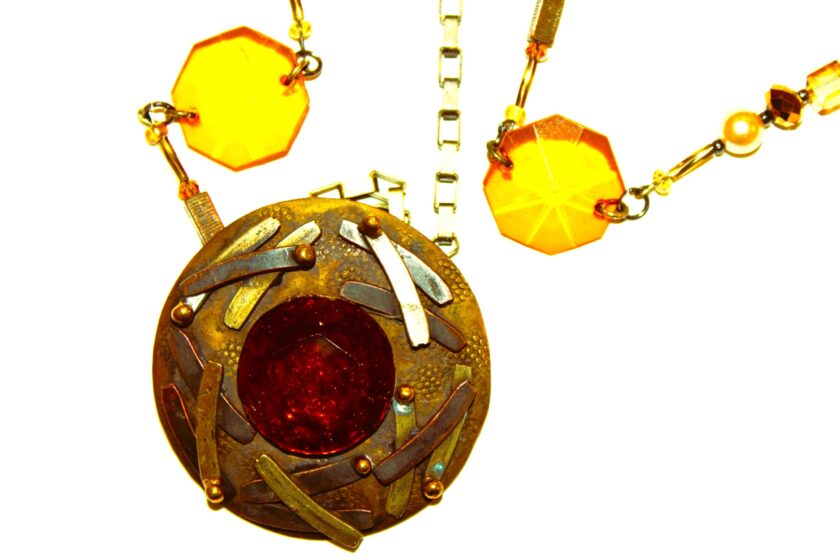 A gold necklace with amber cut stone pendant.