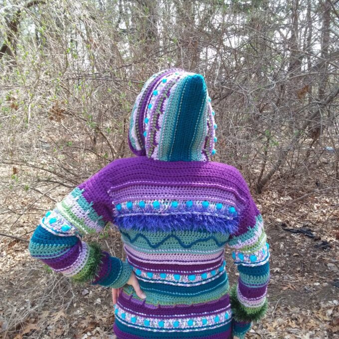 A woman wearing a purple sweater in the woods.