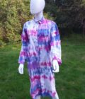 A tie dye upcycled duster dress in shades of pink, blue and purple.