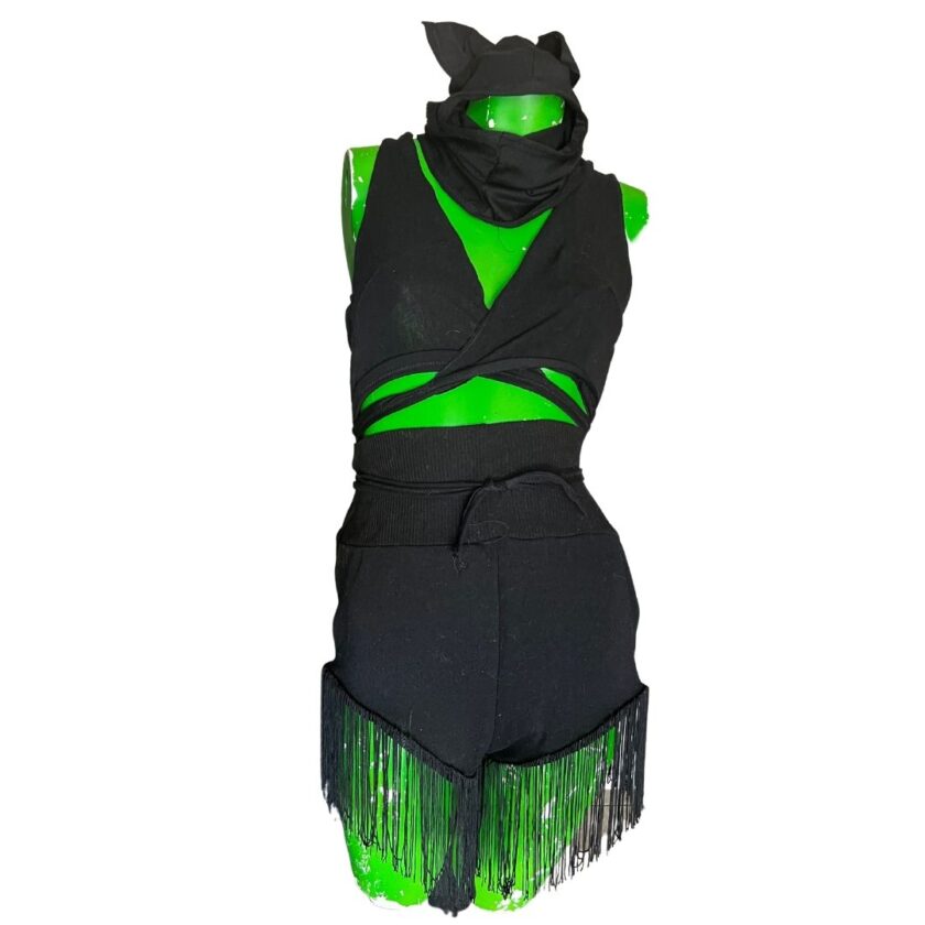 A mannequin wearing a black outfit with green fringes.