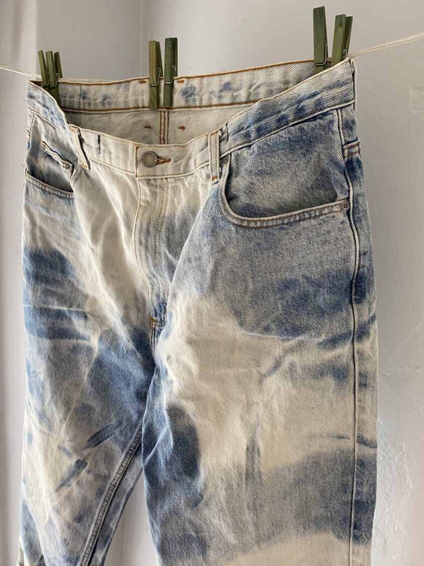 A pair of jeans hanging on a clothes line.