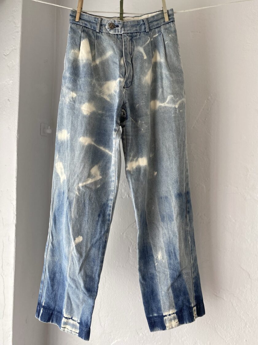 Front of bleached denim jeans hanging on clothes line.