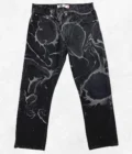 A pair of black jeans with black paint on them.