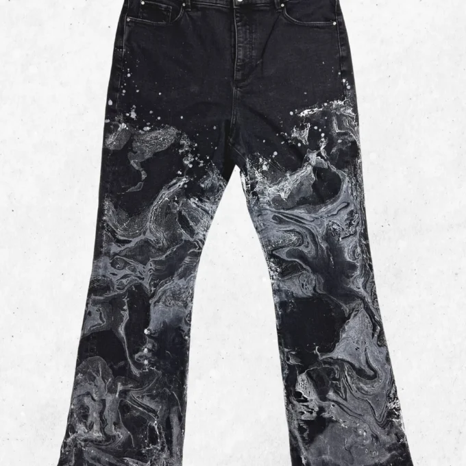 A pair of black jeans with white paint on them.