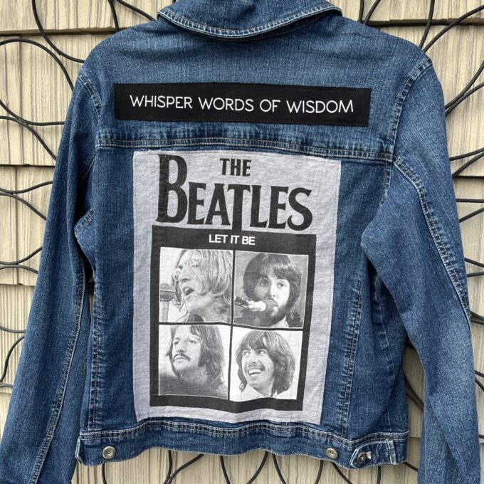 A denim jacket with the beatles on it.