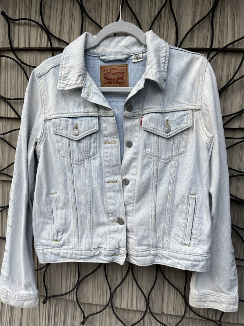 A levi's denim jacket hanging on a wall.