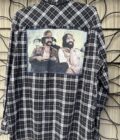 A flannel shirt with a picture of two men on it.