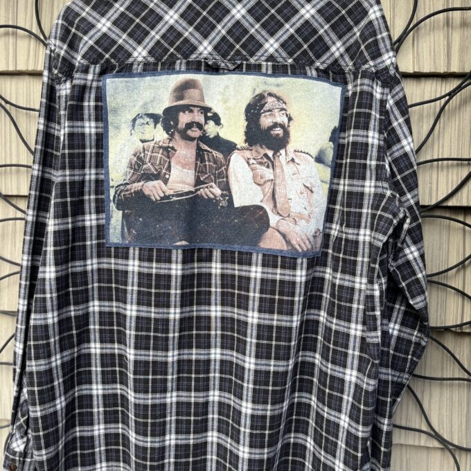 A flannel shirt with a picture of two men on it.