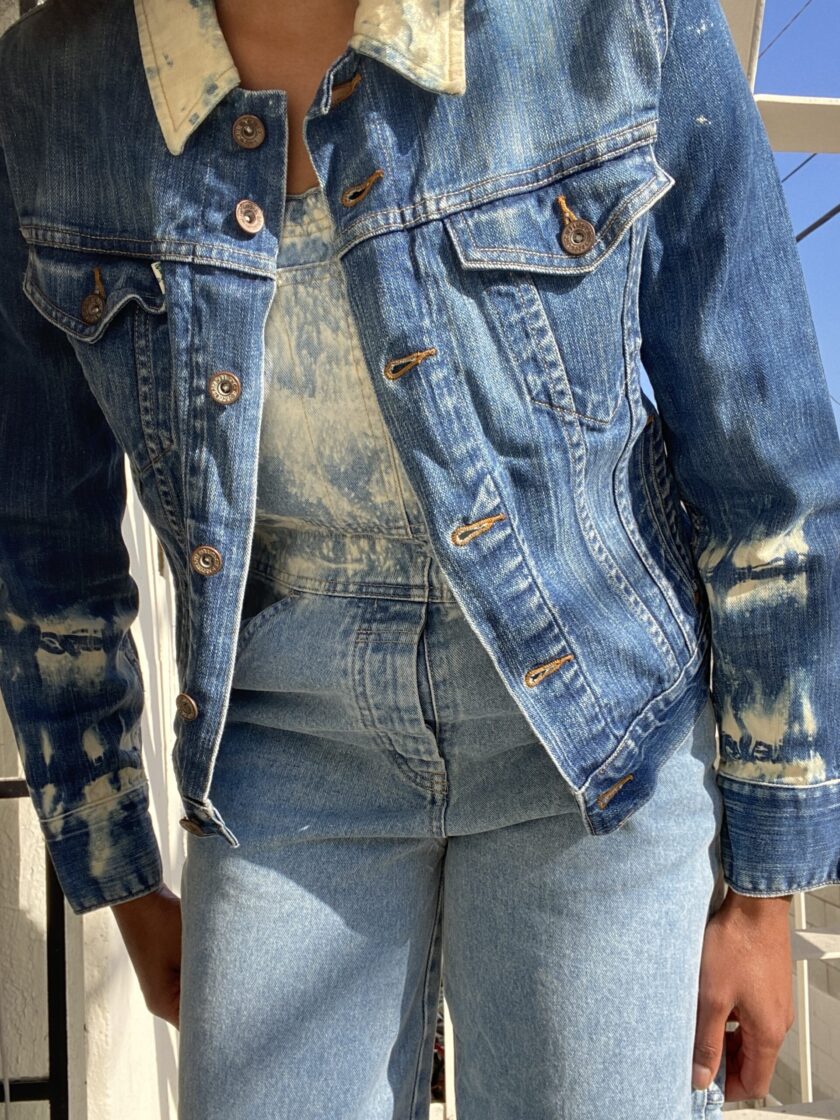 A woman wearing a denim jacket and jeans.