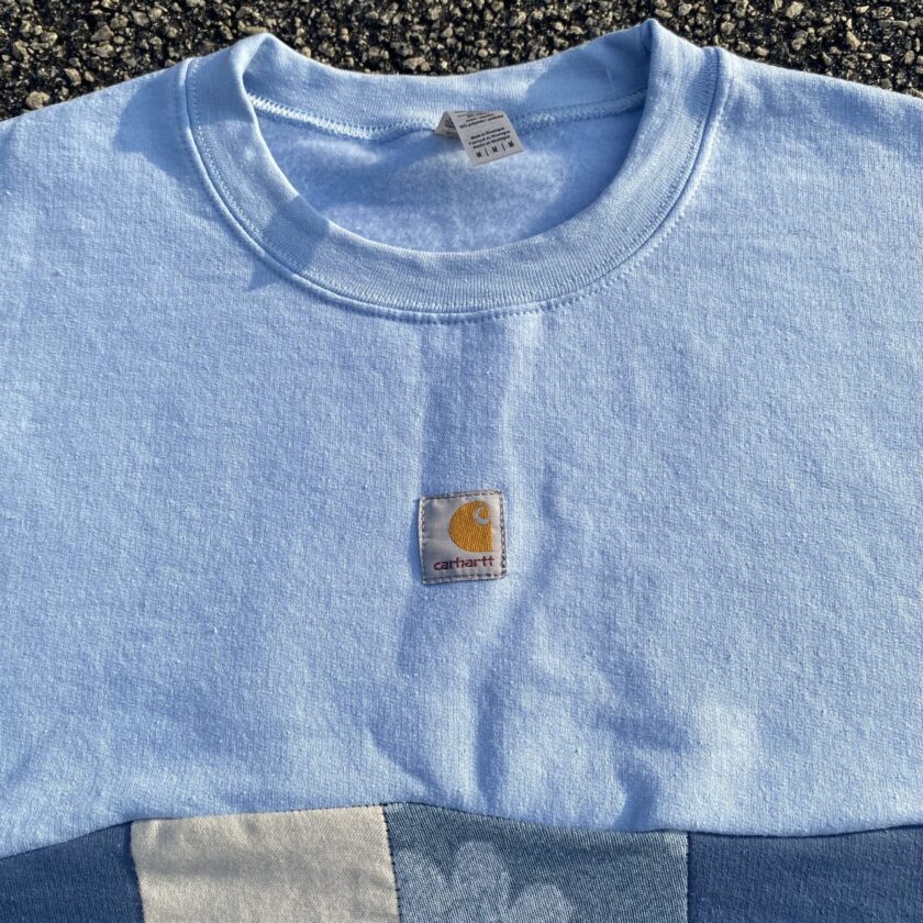 A carhartt blue t - shirt with a patch on it.