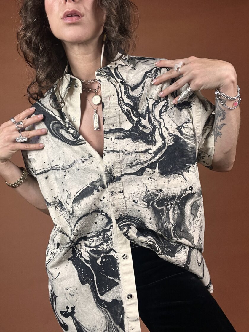A woman wearing a black and white marbled shirt.