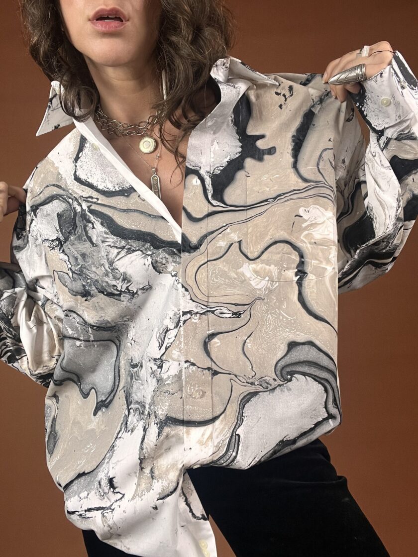 A woman wearing a shirt with a marble print.