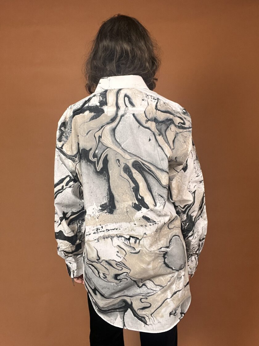 The back of a woman wearing a black and white marbled shirt.