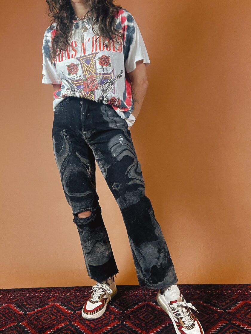 A woman wearing ripped jeans and a t - shirt.