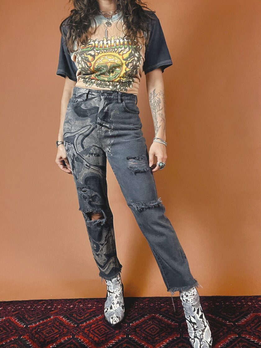 A woman wearing ripped jeans and a t - shirt.