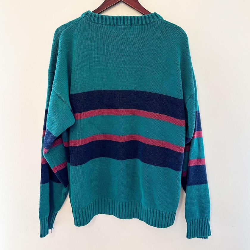 A teal sweater with red and blue stripes hanging on a hanger.