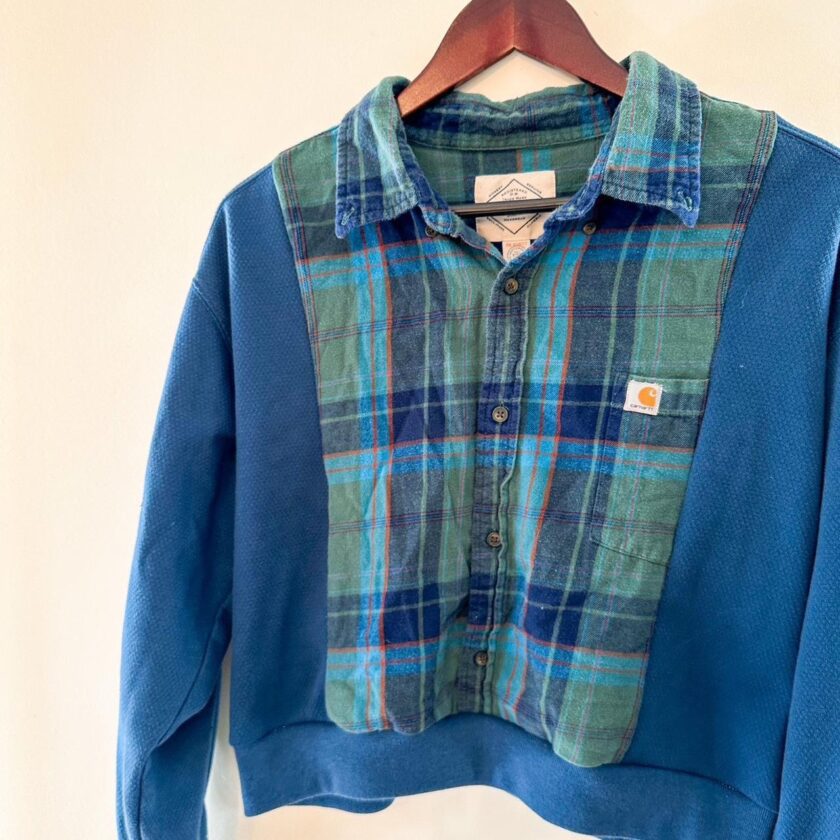 A blue and green plaid shirt hanging on a hanger.