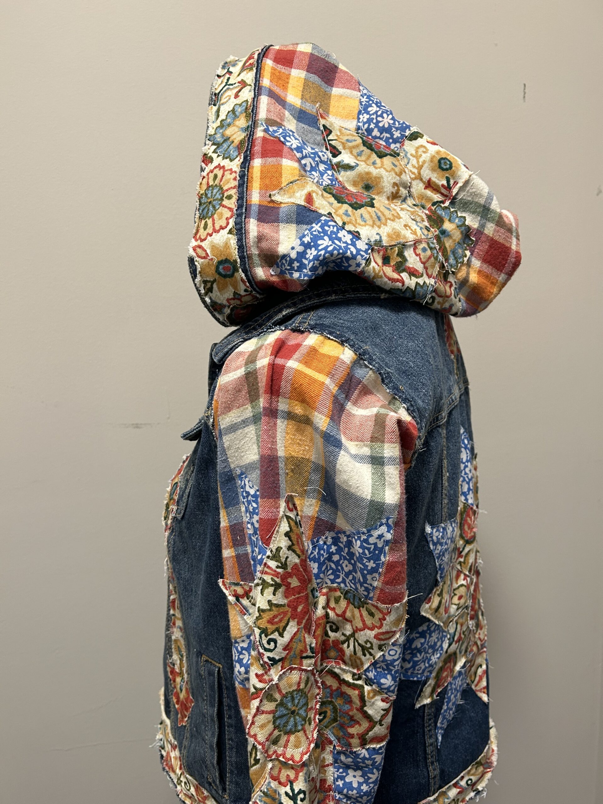 A hooded denim jacket with a floral pattern.