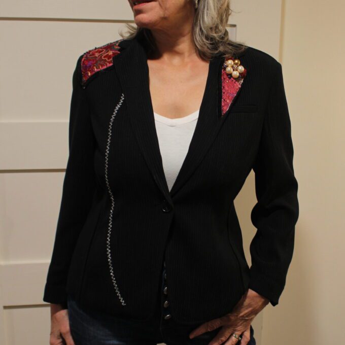 A woman wearing a black blazer and jeans.