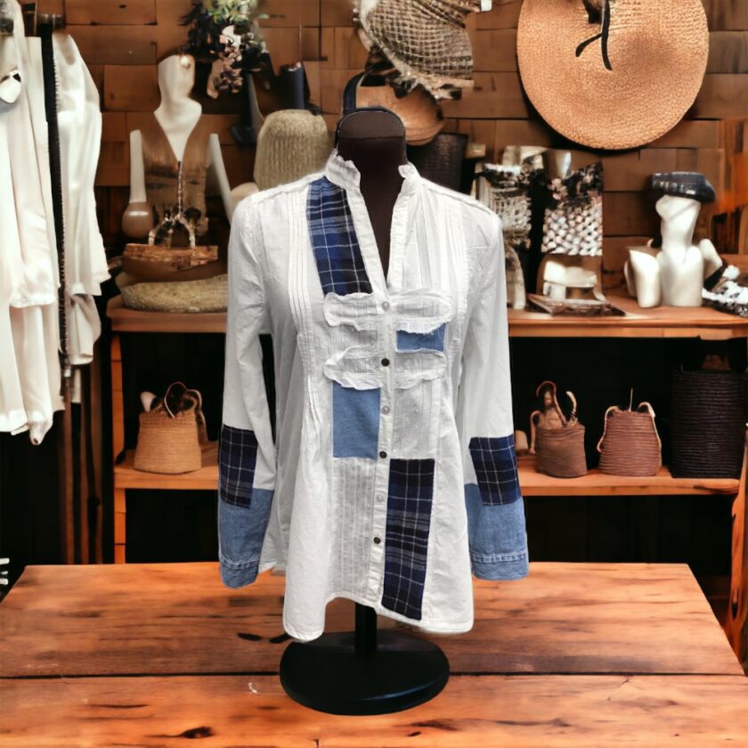 A mannequin displaying a white shirt and hats.