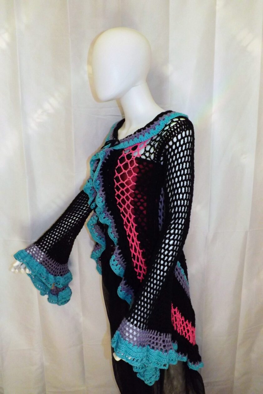 A crochet duster with flowing bell sleeves made from recycled yarns.