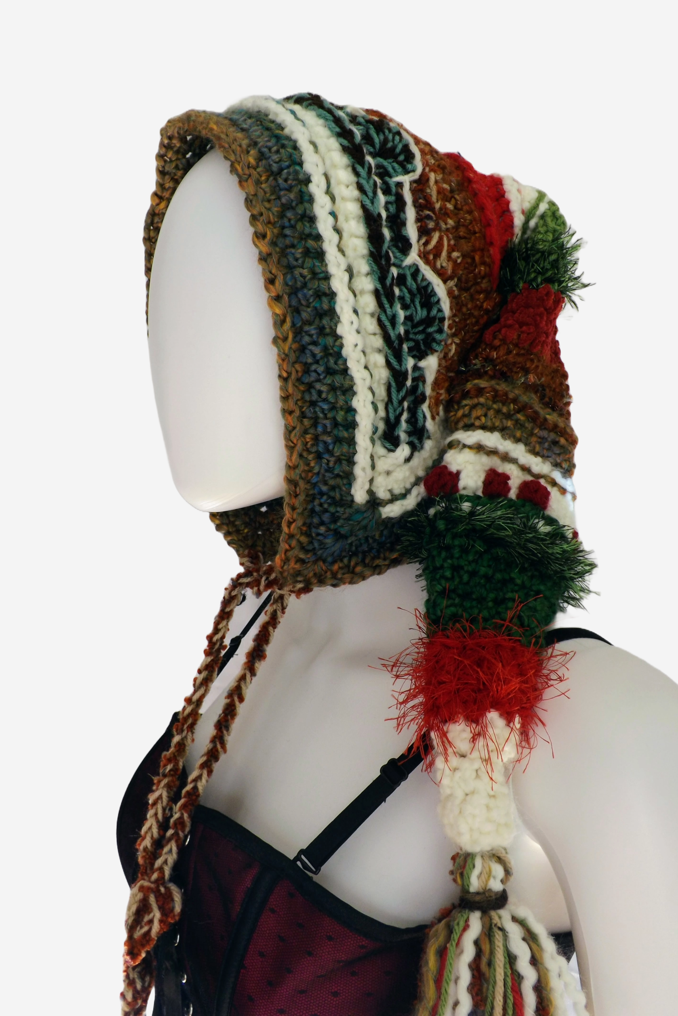 Crochet elf hood in browns, greens, reds and white has a long stocking cap and tassel end