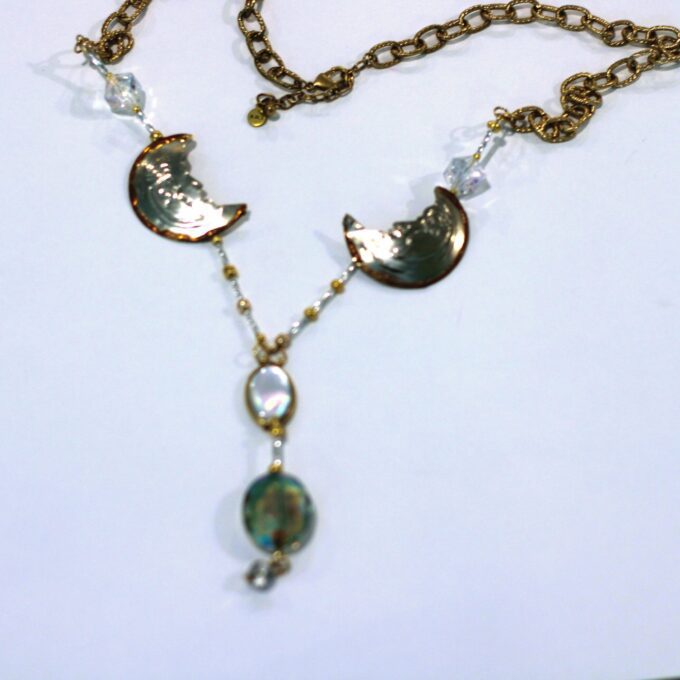 A necklace with a glass pendant and a gold chain.