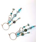A pair of earrings with blue glass beads on them.
