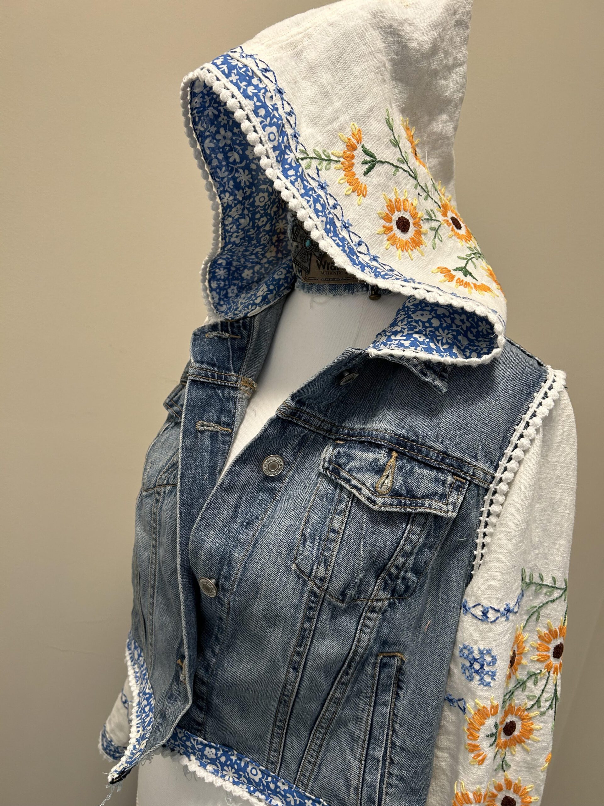 A mannequin with a denim jacket and hoodie.