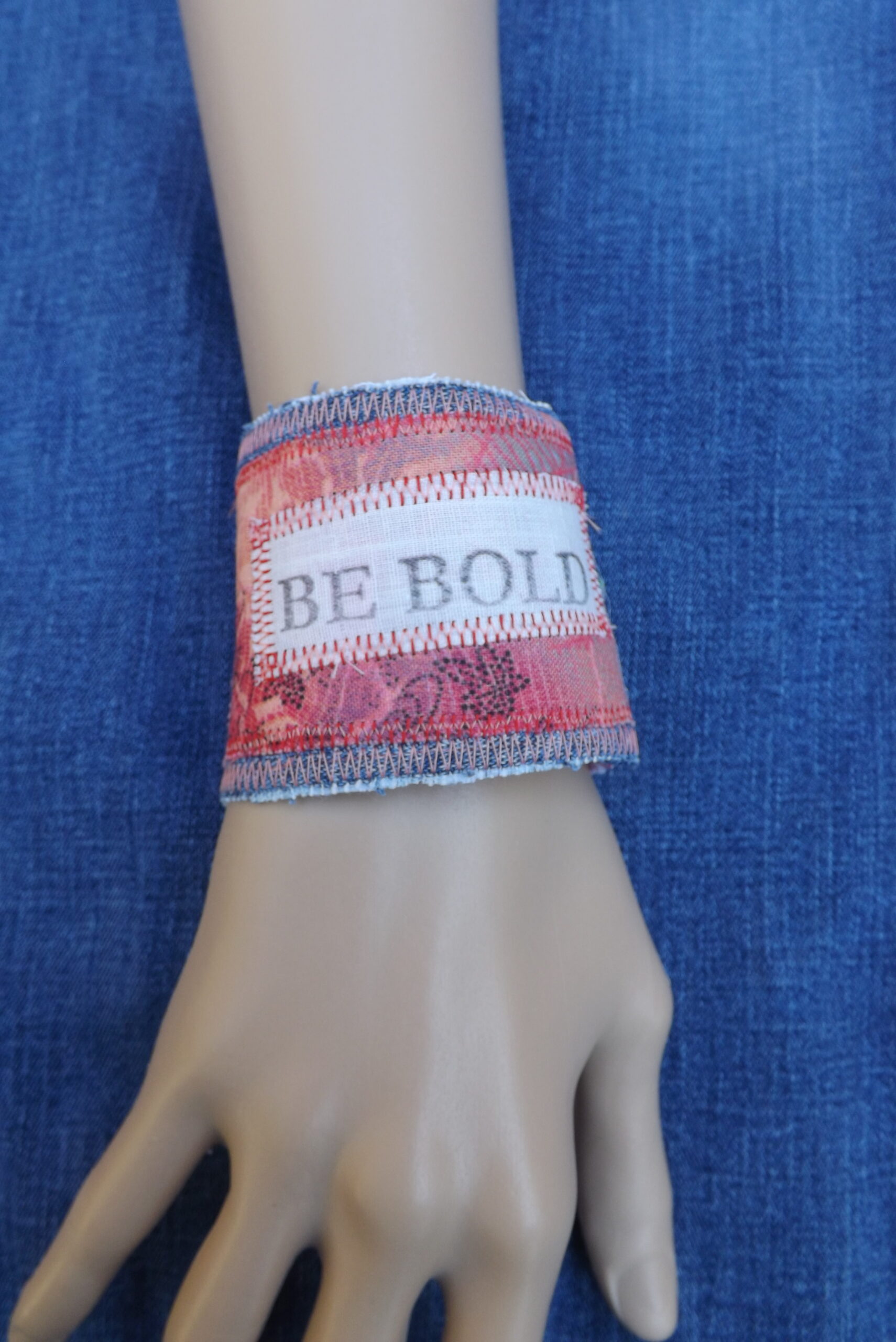 Scrappy denim cuff bracelet with Be Bold stamped upon it.
