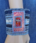 An upcycled denim cuff bracelet with dragonfly charm.