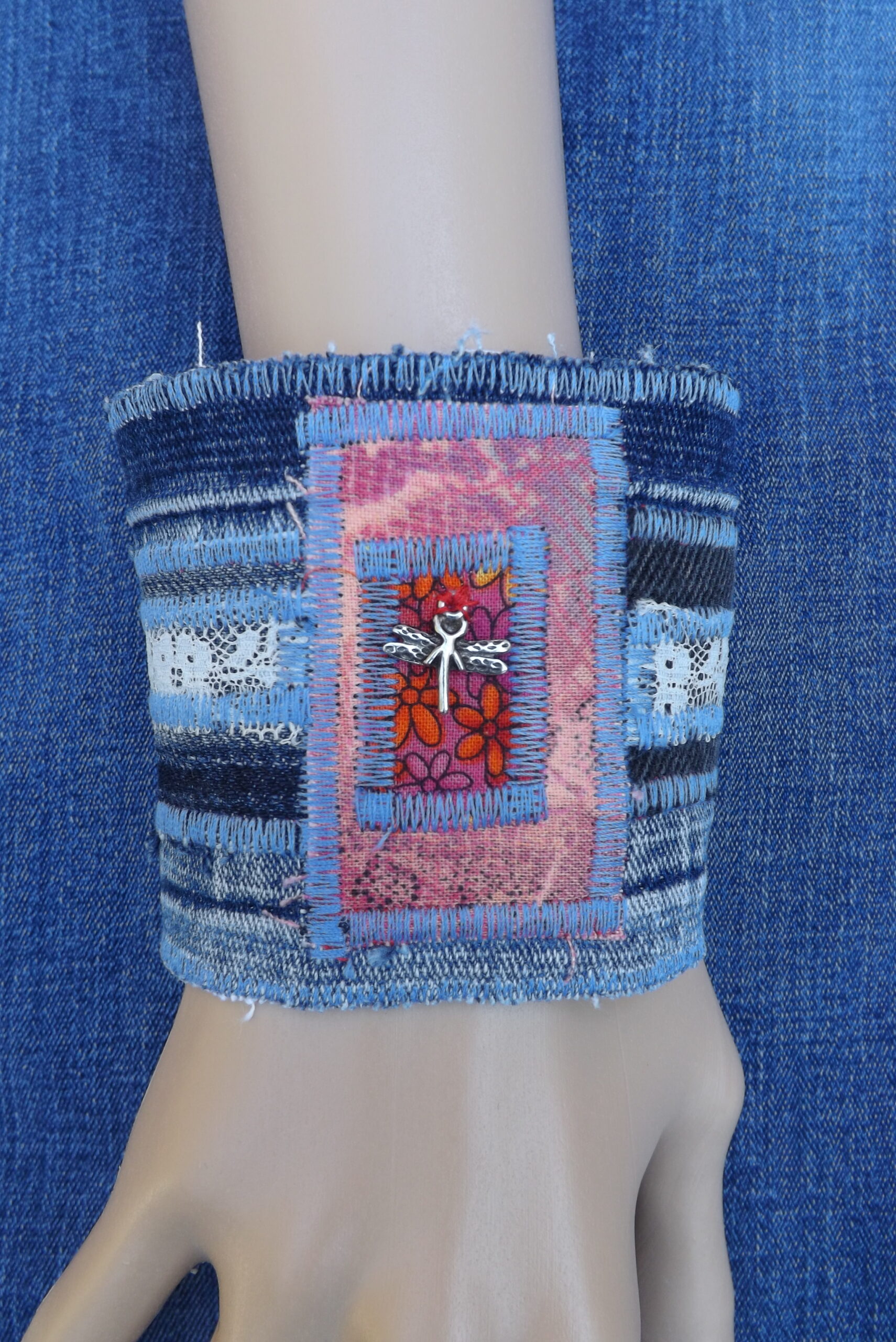 An upcycled denim cuff bracelet with dragonfly charm.