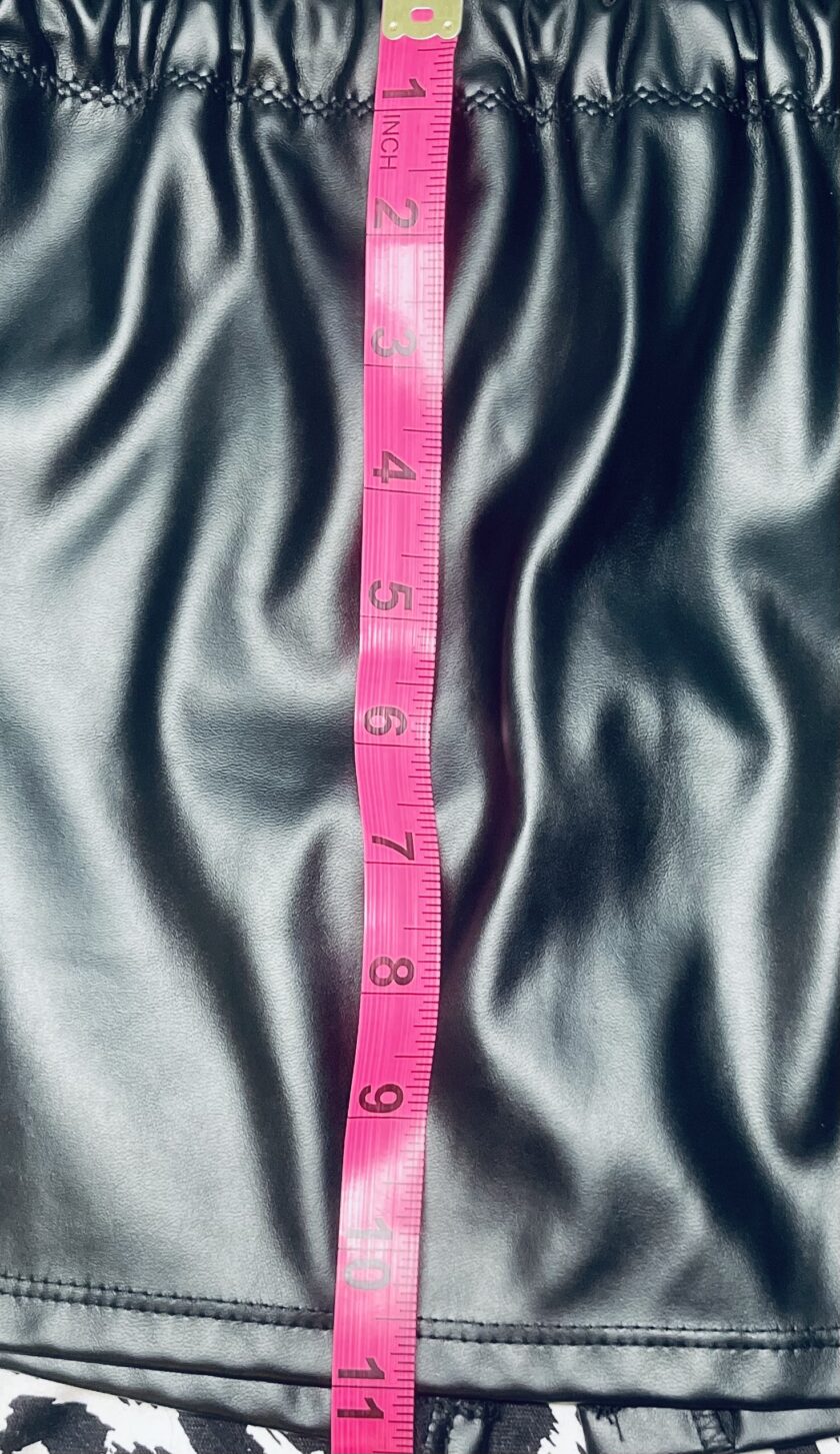 A black leather skirt with a pink measuring tape.