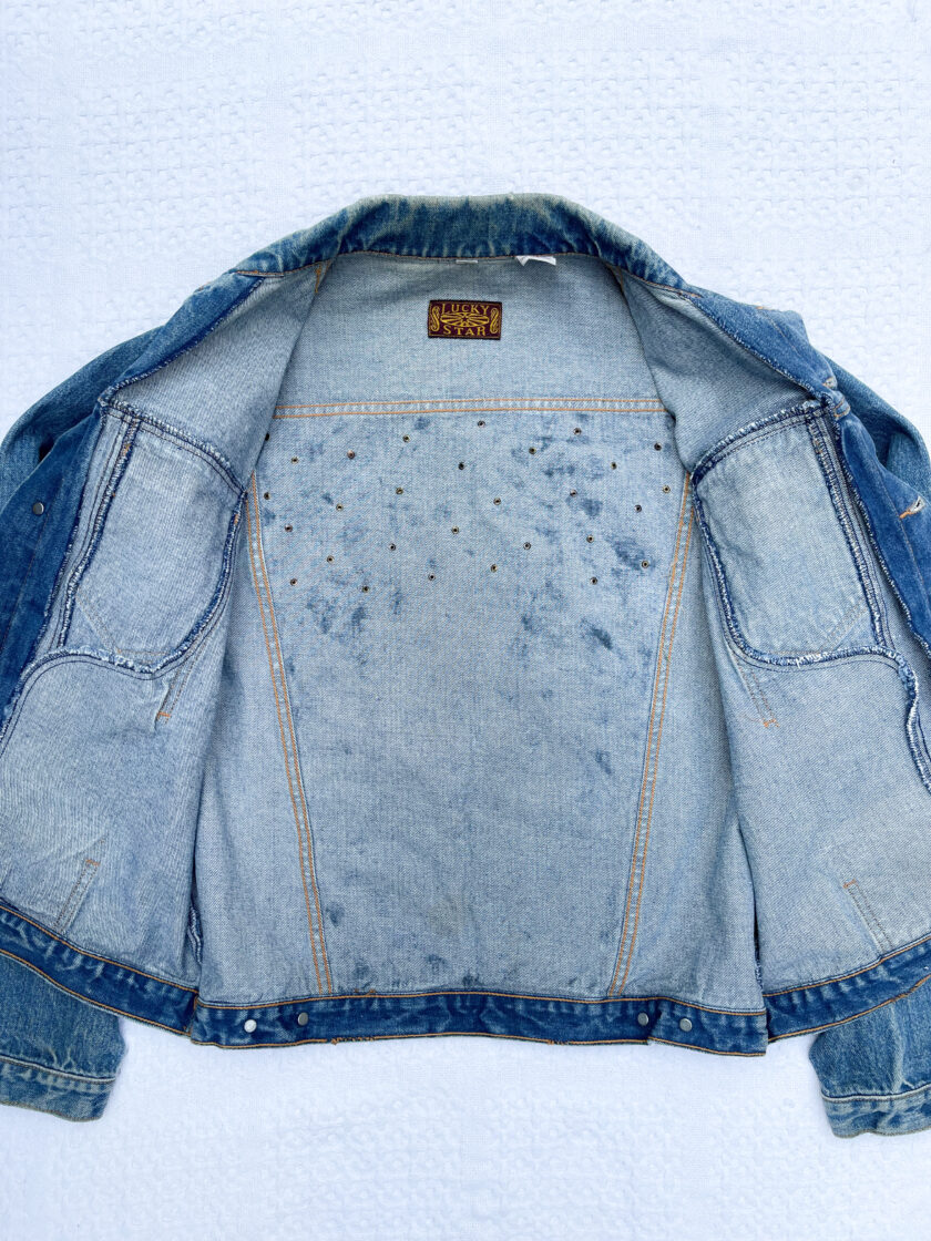 The back of a denim jacket with studs on it.