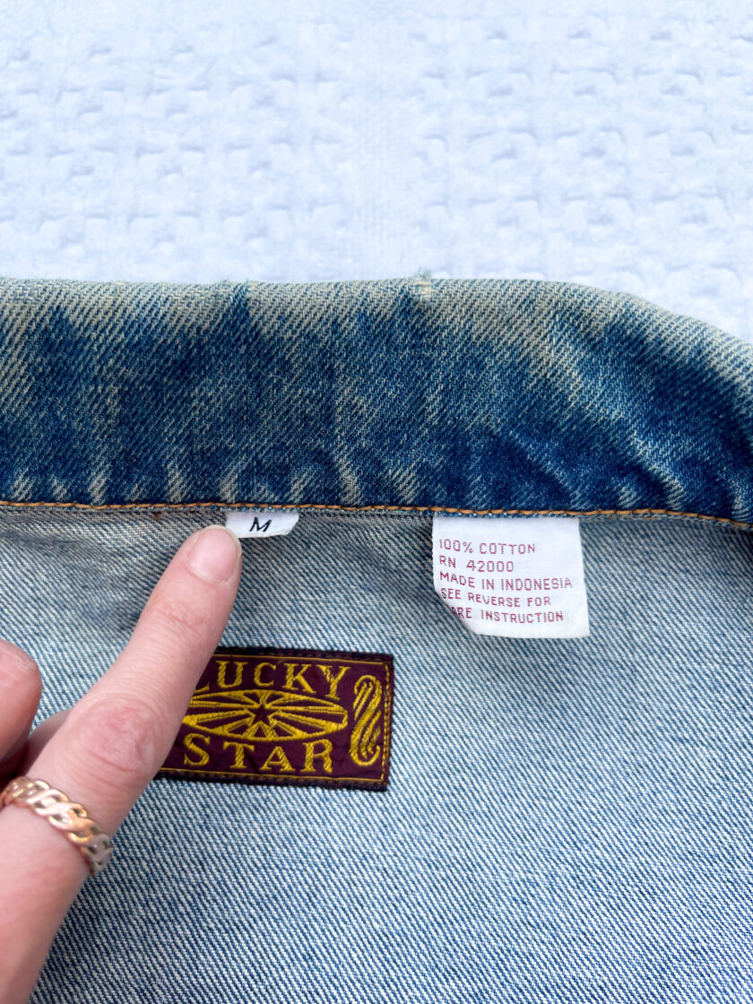 A person is putting a label on a denim jacket.