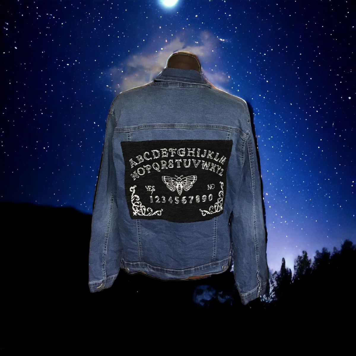 A denim jacket with a moon and stars on it.