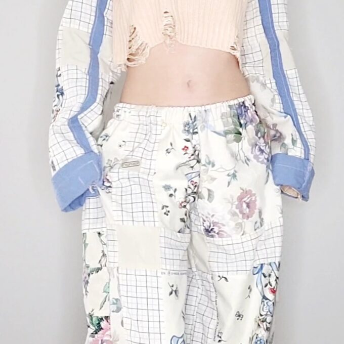 A woman wearing a floral top and pants.