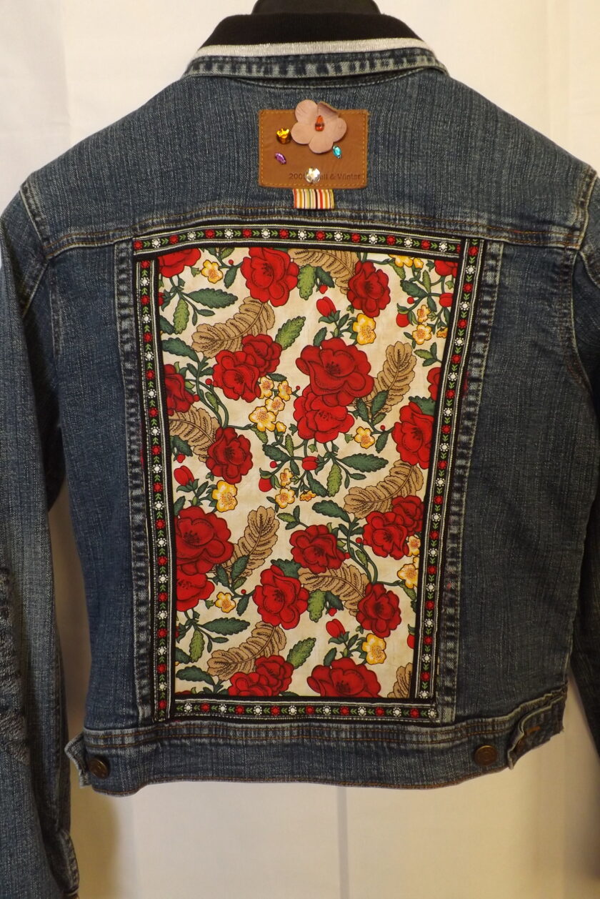A denim jacket with red roses fabric and vintage floral trim