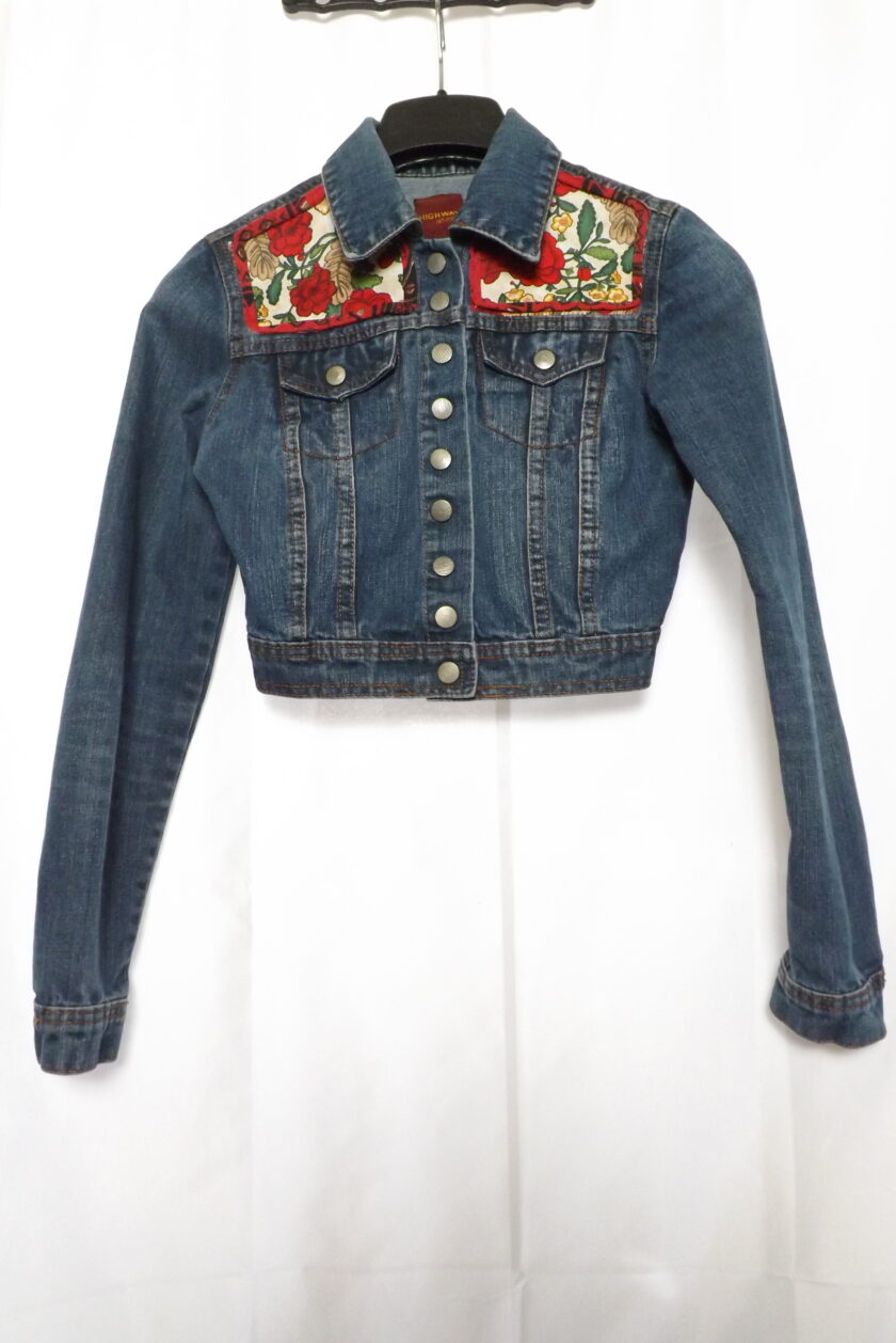 An upcycled denim jacket with vintage roses fabric on it.