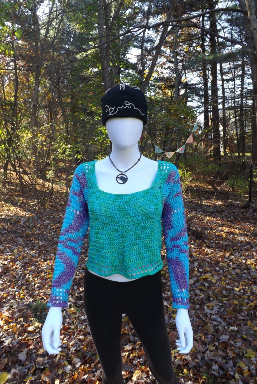 A purple, blue and green crochet sweater.