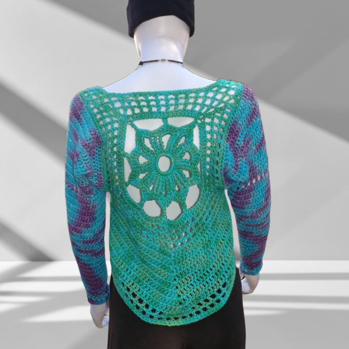 A crochet sweater with sun design in shades of green, blue and purple.
