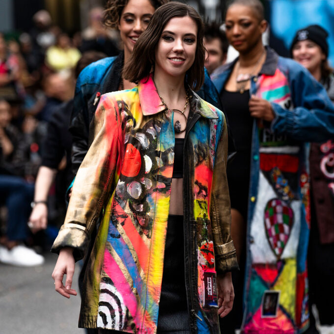 A woman in a colorful jacket walking down the street.