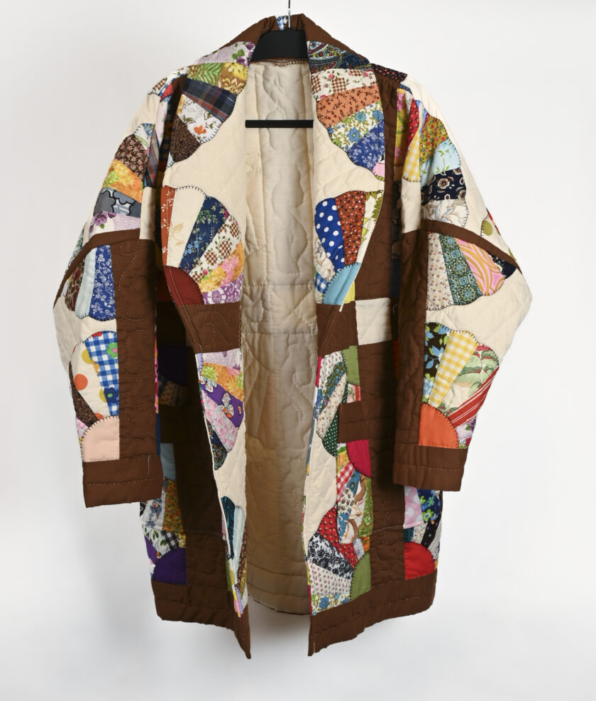 A quilted jacket hanging on a hanger.