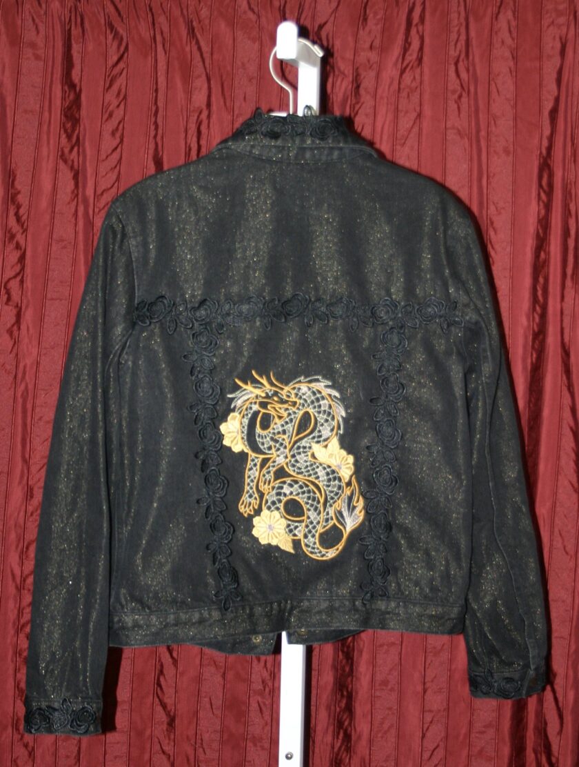 A black denim jacket with a gold dragon embroidered on it.